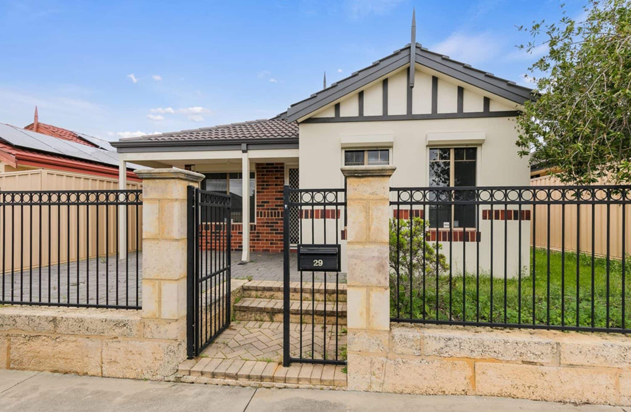 Rendered house behind a wrought-iron fence