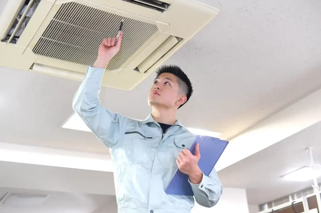 Inspector checking an air conditioning unit as part of property due diligence for potential buyers.